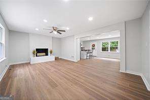 unfurnished living room with hardwood / wood-style flooring and ceiling fan