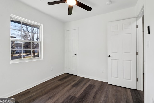 unfurnished bedroom featuring ceiling fan and dark hardwood / wood-style flooring