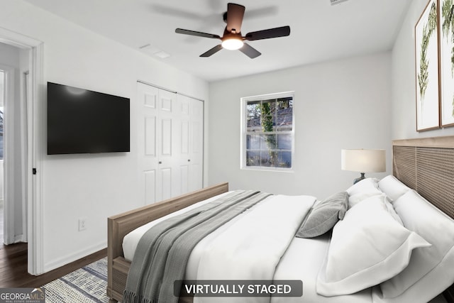 bedroom featuring dark hardwood / wood-style floors, ceiling fan, and a closet