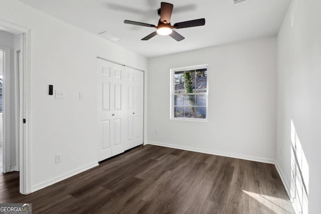 unfurnished bedroom with dark hardwood / wood-style floors, ceiling fan, and a closet