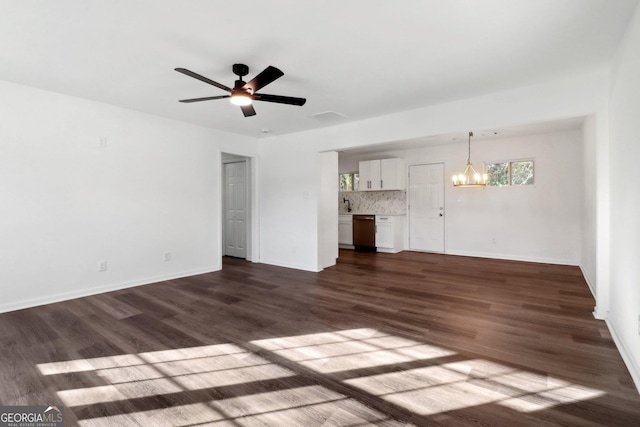 unfurnished living room featuring dark hardwood / wood-style flooring and ceiling fan with notable chandelier