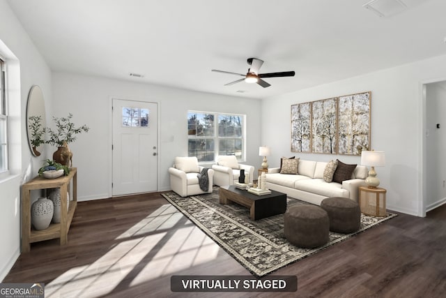 living room featuring dark wood-type flooring and ceiling fan