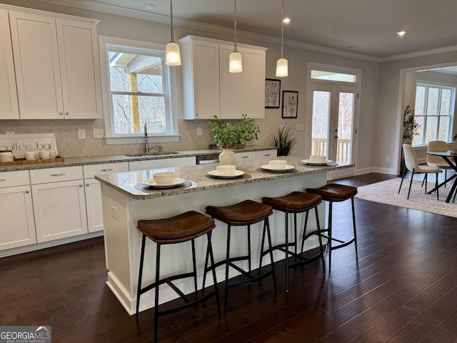 kitchen with dark wood-style floors, french doors, ornamental molding, and a sink