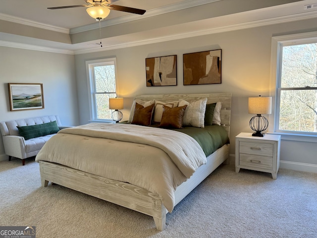 bedroom with a raised ceiling, ornamental molding, light carpet, ceiling fan, and baseboards