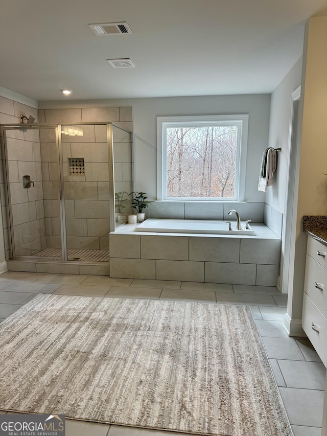 bathroom featuring tile patterned flooring, a garden tub, vanity, visible vents, and a shower stall