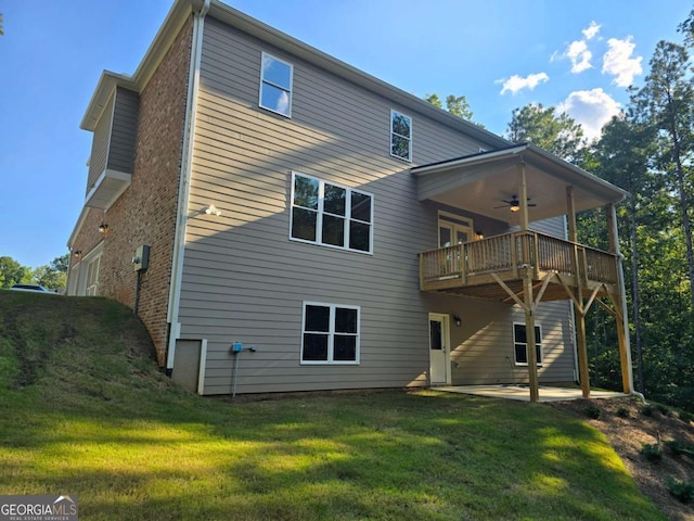 rear view of house with brick siding, a lawn, a patio area, ceiling fan, and a deck