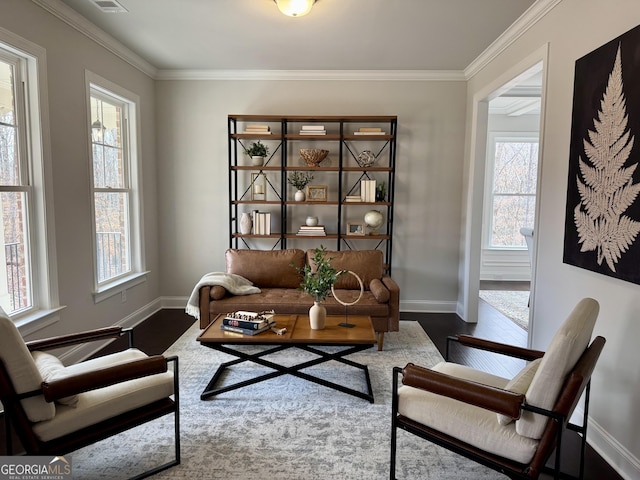 living area featuring baseboards and crown molding