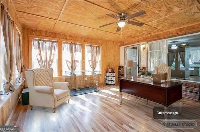 home office featuring ceiling fan and wood walls