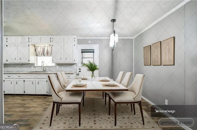 dining space featuring ornamental molding, sink, and dark hardwood / wood-style floors