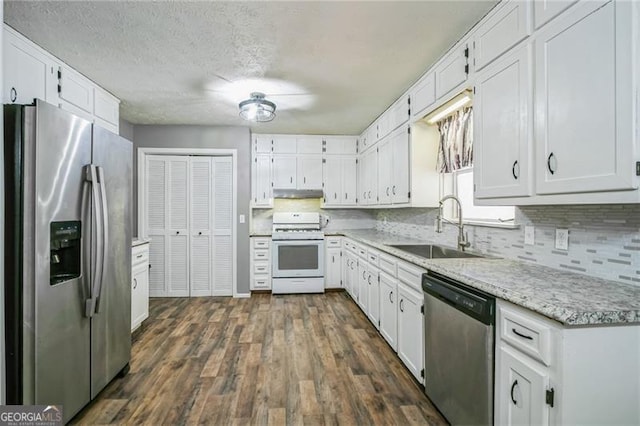 kitchen with appliances with stainless steel finishes, sink, and white cabinets