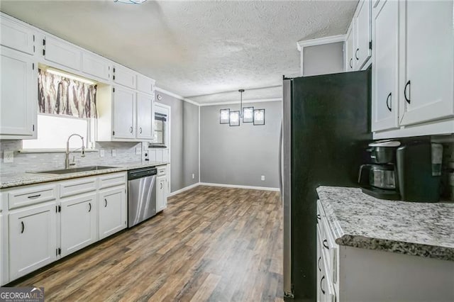 kitchen with appliances with stainless steel finishes, tasteful backsplash, white cabinetry, sink, and hanging light fixtures