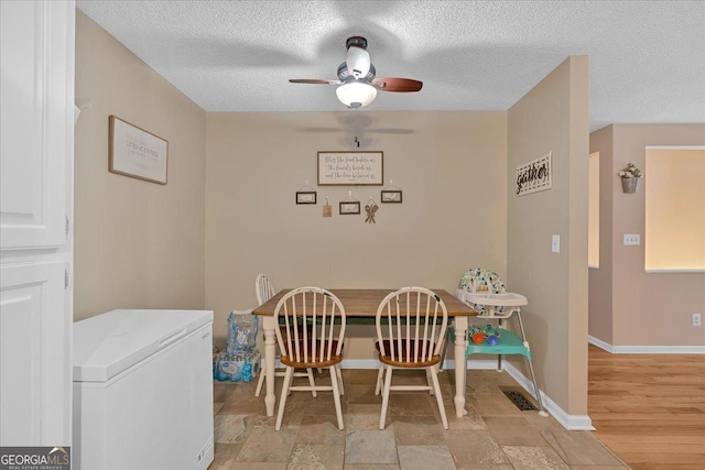 dining room with ceiling fan and a textured ceiling