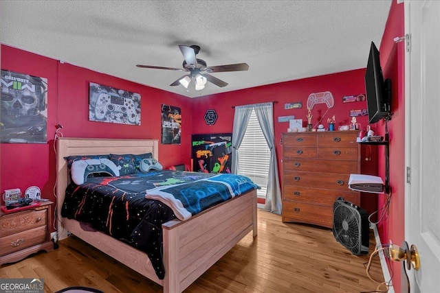 bedroom featuring a textured ceiling, wood-type flooring, and ceiling fan