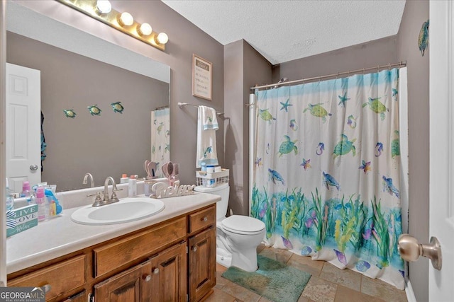 bathroom with vanity, curtained shower, toilet, and a textured ceiling