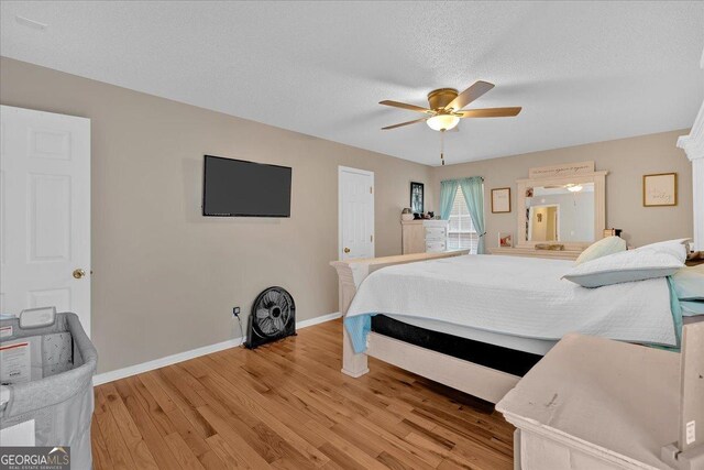 bedroom with ceiling fan, a textured ceiling, and light wood-type flooring