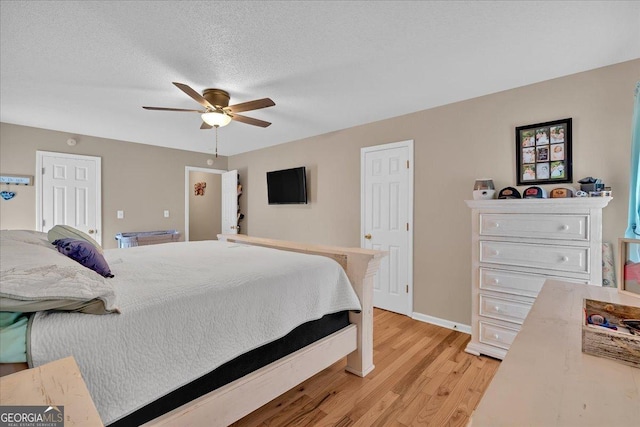 bedroom with ceiling fan, light hardwood / wood-style floors, and a textured ceiling