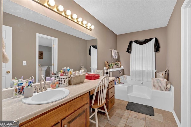 bathroom with vanity, a tub, and a textured ceiling