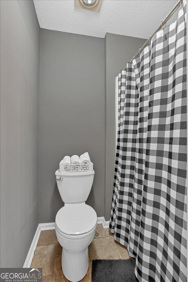 bathroom featuring toilet and a textured ceiling