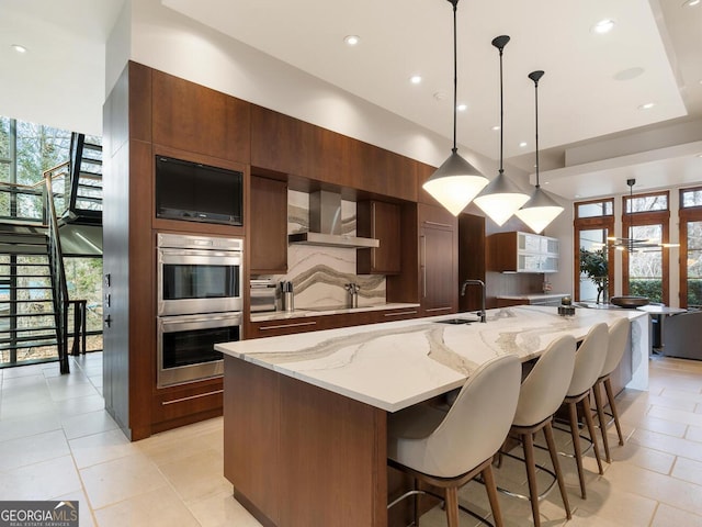 1500 W Wesley Rd NW, Atlanta, GA 30327 - kitchen with double oven, modern cabinets, wall chimney range hood, a large island with sink, and a sink