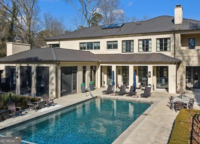 1500 W Wesley Rd NW, Atlanta, GA 30327 - rear view of property featuring metal roof, a chimney, and a standing seam roof