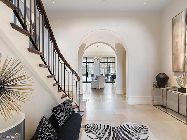 1500 W Wesley Rd NW, Atlanta, GA 30327 - foyer entrance featuring a notable chandelier, arched walkways, baseboards, light tile patterned floors, and stairway