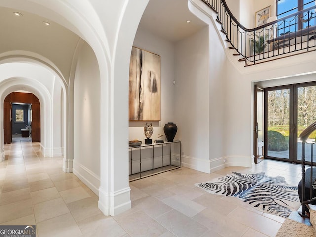 1500 W Wesley Rd NW, Atlanta, GA 30327 - foyer entrance with light tile patterned floors, arched walkways, and baseboards