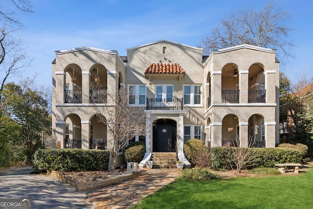 view of front of house with a front lawn and a balcony