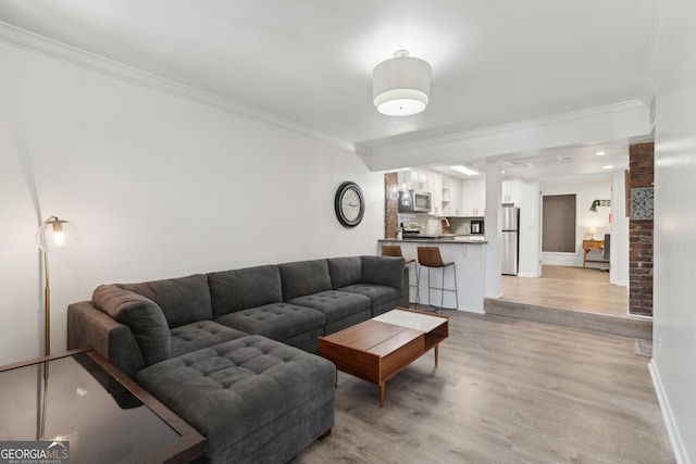 living room featuring ornamental molding and light hardwood / wood-style flooring