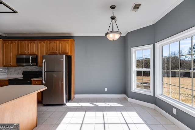 kitchen featuring crown molding, appliances with stainless steel finishes, hanging light fixtures, backsplash, and light tile patterned flooring