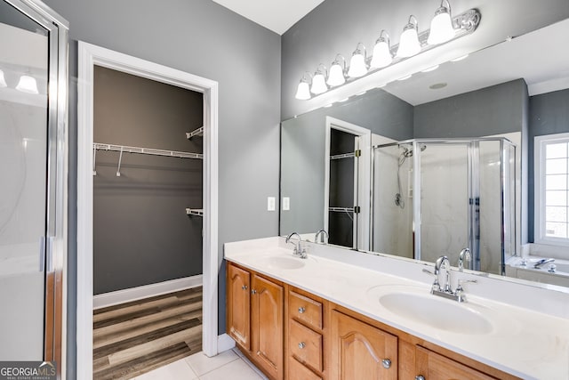 bathroom with tile patterned floors, vanity, and an enclosed shower