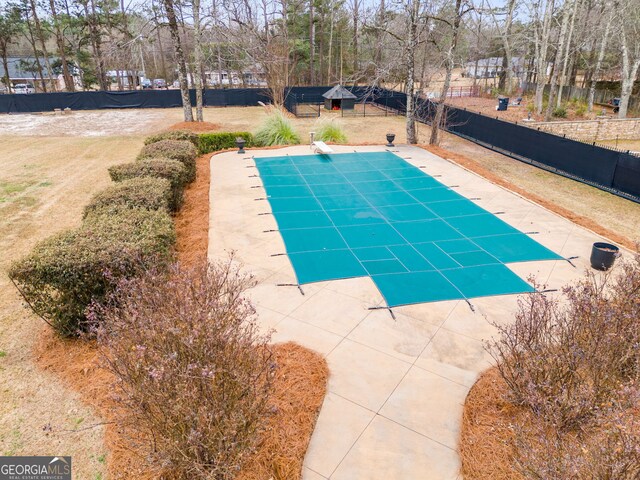 view of swimming pool with a diving board