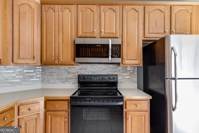 kitchen with appliances with stainless steel finishes, tile patterned flooring, and backsplash