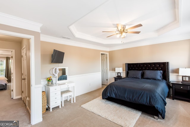 bedroom featuring crown molding, ceiling fan, a tray ceiling, and light colored carpet