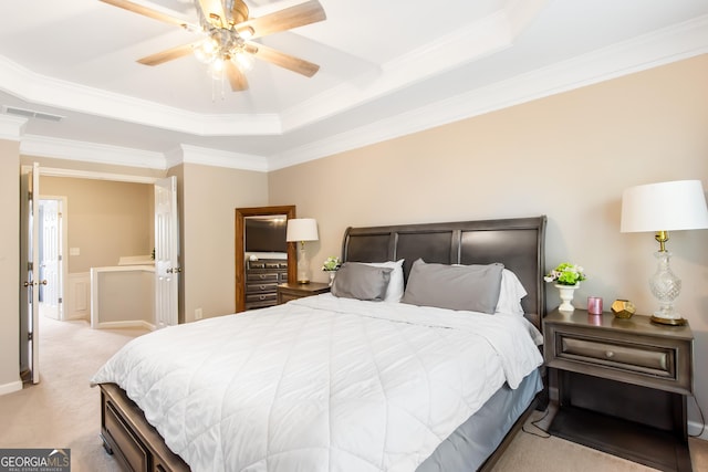 bedroom with crown molding, light colored carpet, ceiling fan, and a tray ceiling