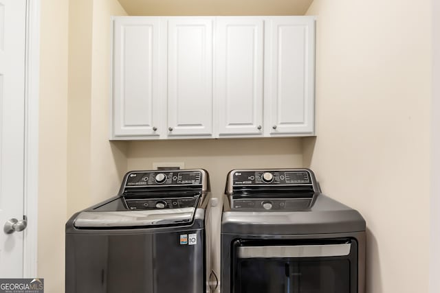 laundry room with cabinets and washing machine and clothes dryer