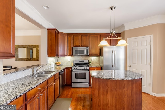 kitchen featuring appliances with stainless steel finishes, dark hardwood / wood-style floors, pendant lighting, sink, and crown molding