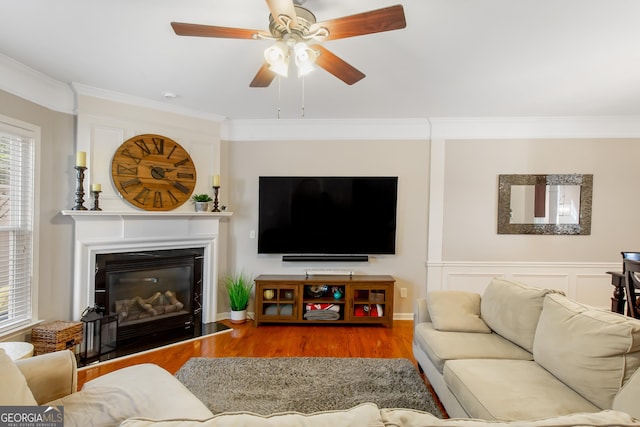 living room featuring hardwood / wood-style flooring, ornamental molding, and ceiling fan