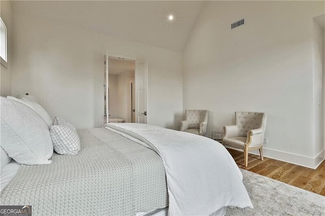 bedroom featuring hardwood / wood-style flooring and high vaulted ceiling