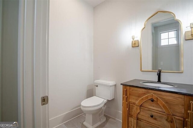 bathroom with vanity, tile patterned floors, toilet, and a tile shower