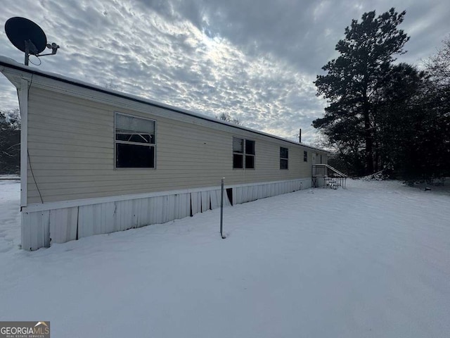 view of snow covered back of property