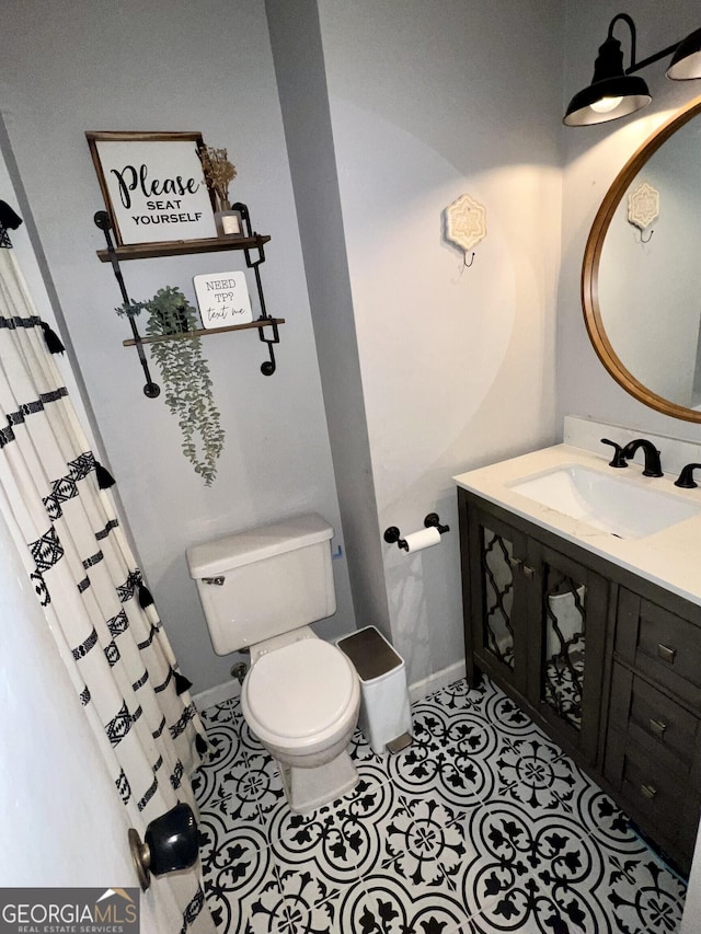 bathroom featuring vanity, toilet, and tile patterned flooring