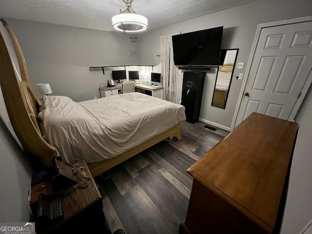 bedroom featuring dark wood-type flooring and a textured ceiling