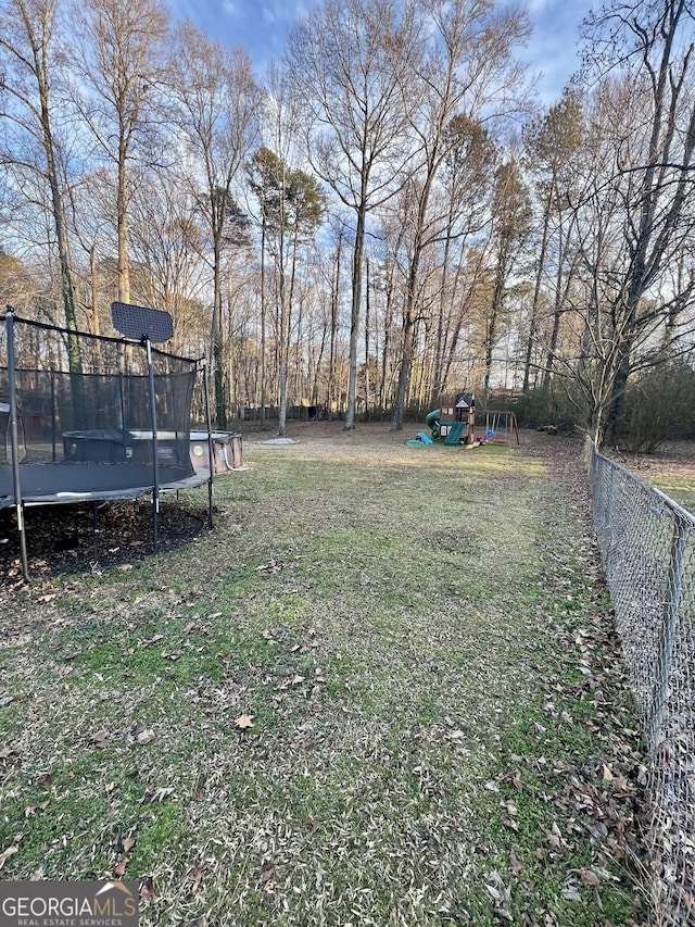 view of yard with a playground and a trampoline