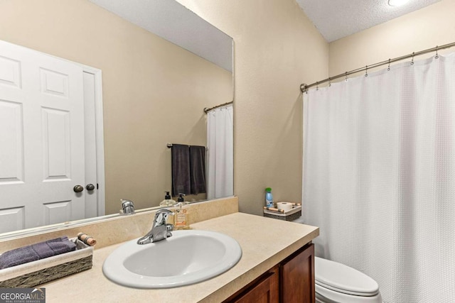 bathroom featuring vanity, toilet, and a textured ceiling