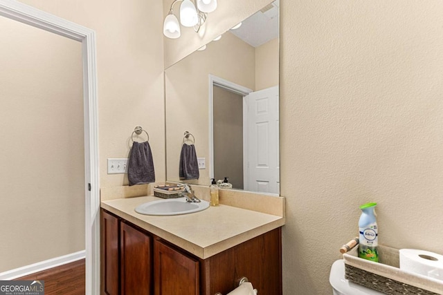 bathroom with hardwood / wood-style flooring, vanity, and toilet