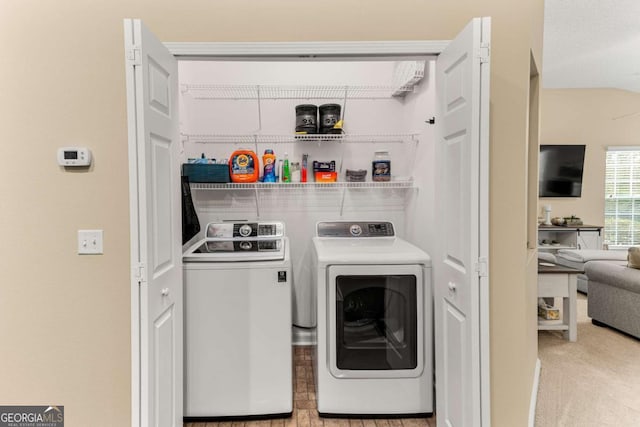 laundry room with independent washer and dryer and light carpet