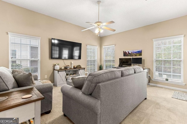 living room featuring ceiling fan, plenty of natural light, and light carpet