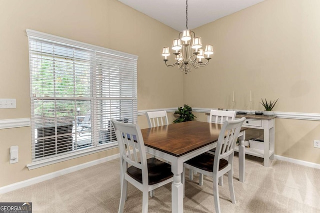 carpeted dining area with a chandelier