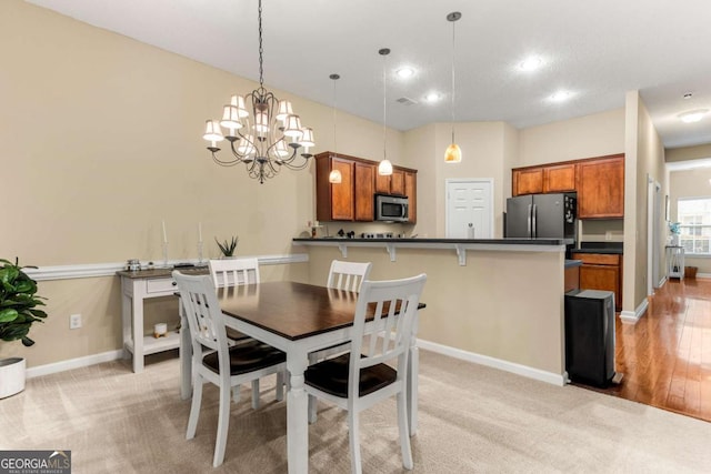 dining space with light carpet and a notable chandelier