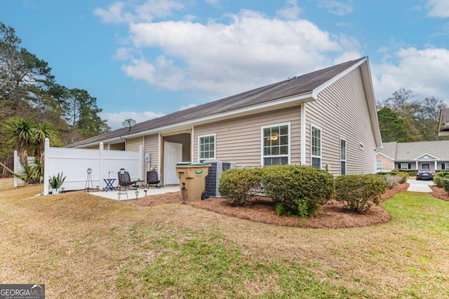 view of front of property featuring cooling unit, a front lawn, and a patio